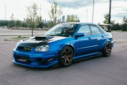 blue Subaru WRX with bronze wheels