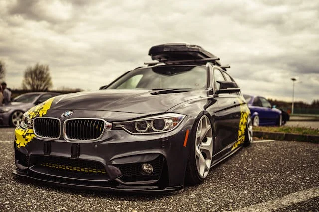 very low bmw with a roof rack on top and yellow vinyl